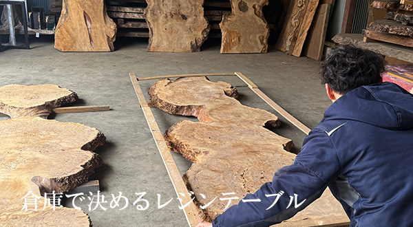 大型の一枚板倉庫でレジンテーブルのデザインをしている様子