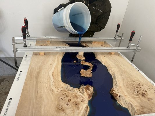 ポプラレジンテーブルにブルーのレジンを流し込む様子