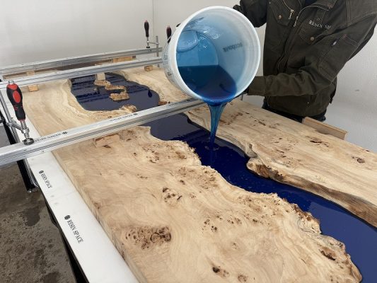 ポプラレジンテーブルにブルーのレジンを流し込む様子