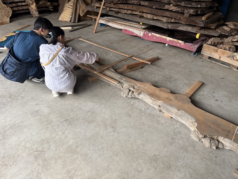 カエデの一枚板を目の前にレジンテーブルのデザインをしているお客様ご家族