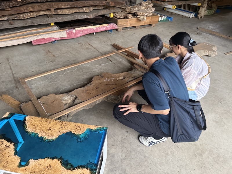 カエデの一枚板を目の前にブルーのレジンテーブルの完成を想像するお客様