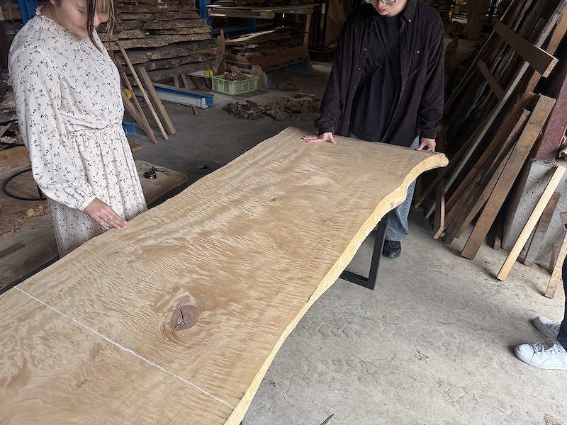 栃の一枚板を目の前にレジンテーブルのデザインをしているお客様ご家族